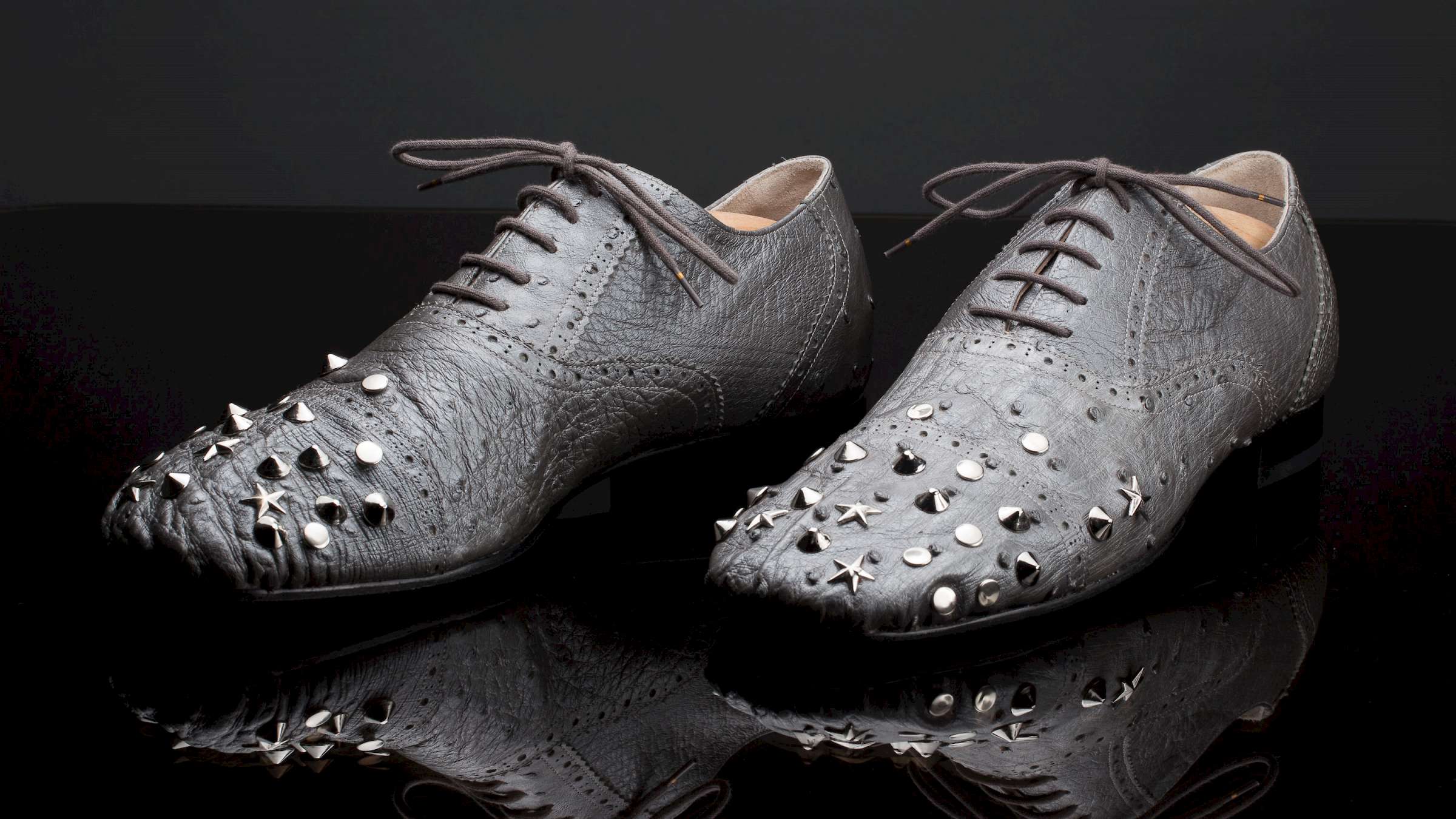 silver ostrich leather bespoke ladies shoe with rivets on black glass